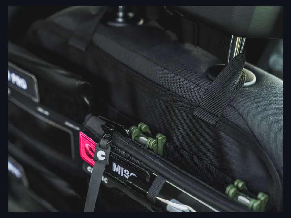 Referência visual de uma bolsa organizadora presa às hastes do apoio de cabeça
