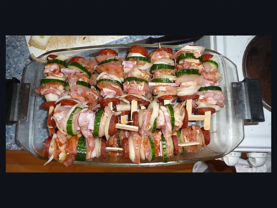 Referência visual de espetos apoiados em um descanso para churrasco