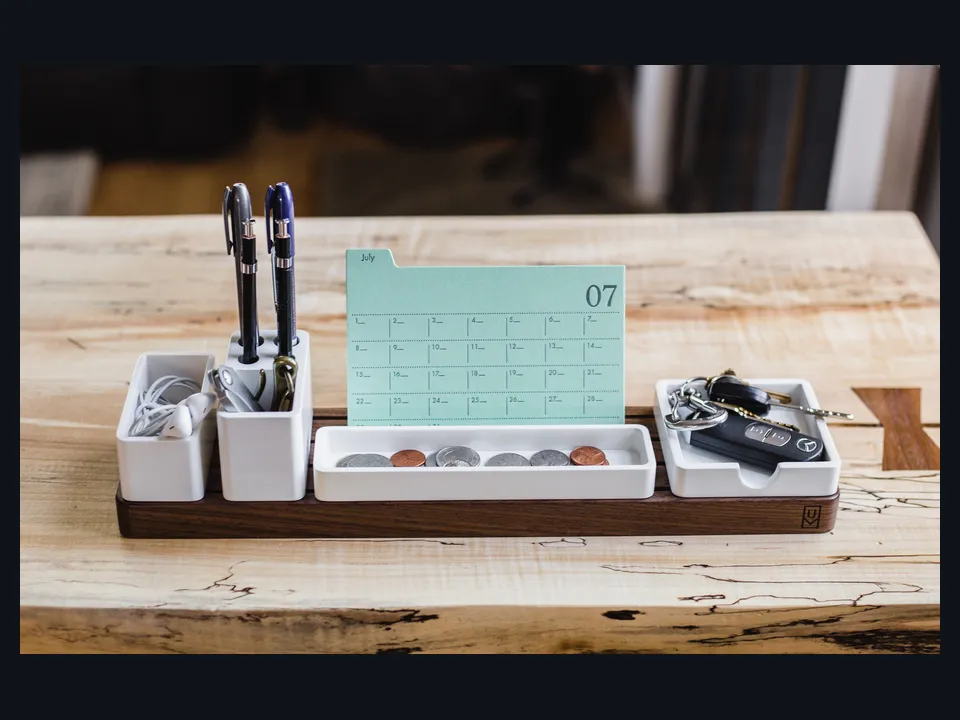 Referência visual de um dock organizador de mesa para celular e objetos pessoais